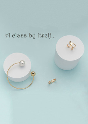 Minimalist jewelry display featuring rings, pearl and gold accessories on white pedestals.