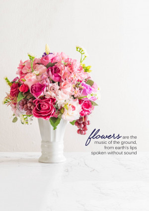 A white vase filled with a vibrant bouquet of pink and purple flowers on a marble surface.