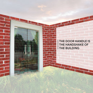 A glass door with metal handles set into a red brick wall.