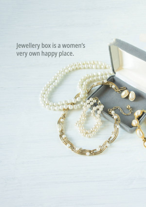 A collection of pearl and gold jewelry displayed on a white wooden surface with an open jewelry box.