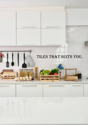 A bright, clean kitchen with white cabinets, subway tile backsplash, and a wooden countertop displaying fresh vegetables and cooking utensils.