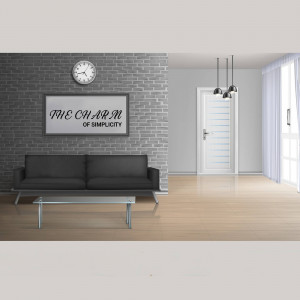 A minimalist living room with a gray brick wall, black sofa, and white door.