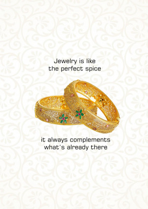 Close-up of two ornate golden bangles with red and green gemstone accents.