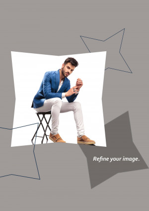 A man sitting on a stool, wearing a blue blazer and white pants.