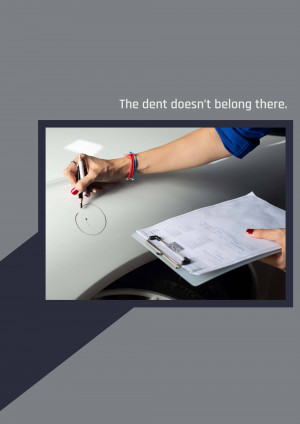 A person circling a dent on a car with a pen while holding a clipboard.