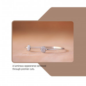 Close-up of a silver bangle with diamond accents on a beige surface