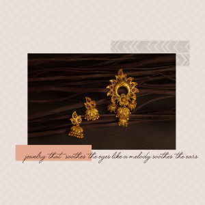 Close-up of a gold jhumka earring set on a dark background
