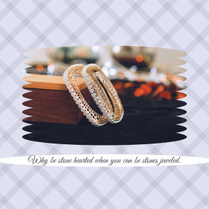 Close-up of two diamond bangles on a wooden surface with a decorative background.