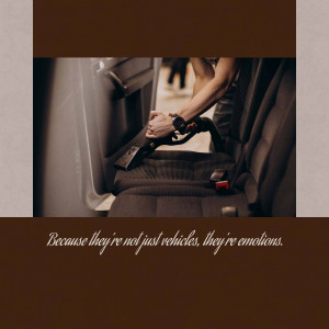 Close-up of a person vacuuming a car interior, focusing on the seat and seatbelt.