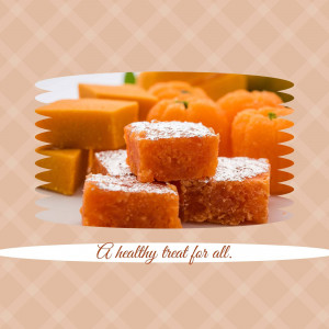 A plate of orange-colored Indian sweets with powdered sugar on top.