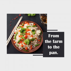 A top-down view of a colorful vegetable stir-fry with noodles, served on a dark plate with chopsticks and a glass of liquid.