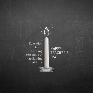 A lit candle with chalk writings on a blackboard, celebrating Teacher's Day.
