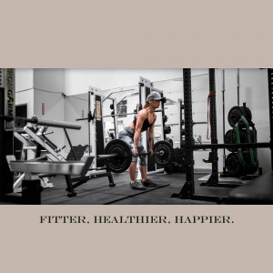 A woman performing a deadlift in a gym setting.