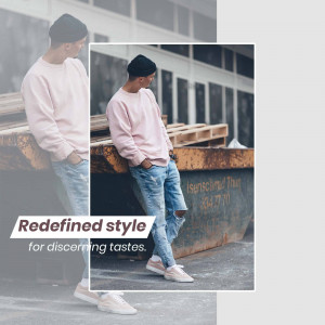 Man in a pink sweatshirt and ripped jeans leaning against wooden pallets.