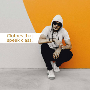 A man wearing a hoodie and sunglasses posing against a two-toned orange and grey background.