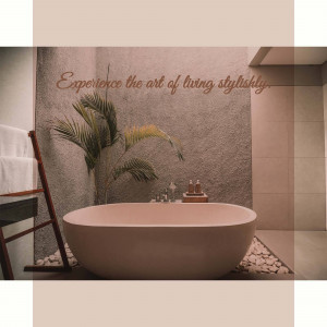 A serene bathroom with a freestanding tub and tropical plants.