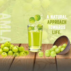 A glass of amla juice with fresh amla fruits