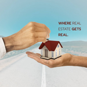 Hands holding a miniature house over a road, symbolizing real estate investment.
