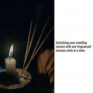 Close-up of incense sticks and a lit candle, evoking a sense of calm and relaxation.
