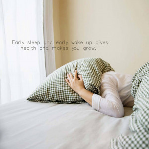 Person hiding face with a pillow in bed