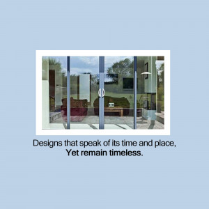 View through glass doors into a modern living room with a sofa and artwork.