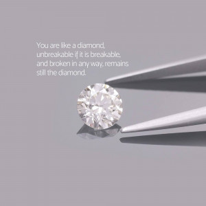 Close-up of a diamond held by tweezers with inspirational text.