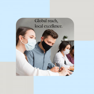 Team members wearing masks collaborating on a project in an office setting.