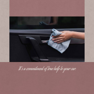 A person cleaning the interior of a car with a blue cloth.