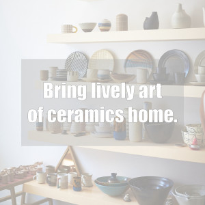 A display of various ceramic bowls, plates, and mugs on wooden shelves in a home decor setting.