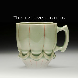 Close-up of a uniquely shaped, light green ceramic mug with red detailing.