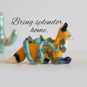 A decorative figurine of a fox with a snake wrapped around it.