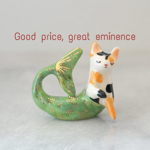 A ceramic figurine of a cat with a mermaid tail.