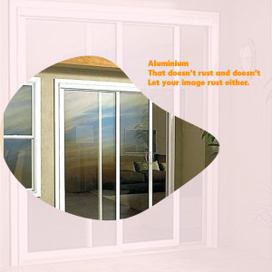 Close-up of an aluminum sliding glass door with a reflection of a living room.