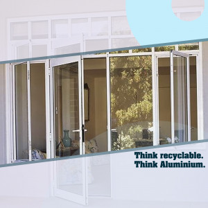 White aluminum sliding windows with a reflection of a room interior and greenery