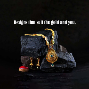 Close-up of a gold necklace and earrings on a dark stone background