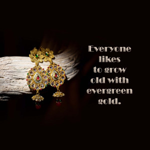 Close-up of ornate gold earrings with red and green gemstones, resting on a textured surface with text overlay.