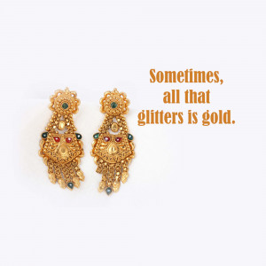 Pair of ornate gold jhumka earrings with green and red gemstone accents