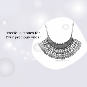 Close-up of a silver necklace with intricate detailing and small stones.