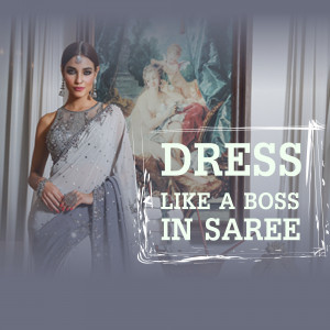 Woman in a stylish grey saree with intricate detailing and jewelry