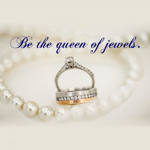 Close-up of a diamond engagement ring and wedding band on a pearl bracelet