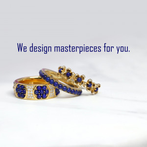Close-up of sapphire and gold rings and bracelet on a marble surface