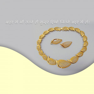 Close-up of a golden necklace and earring set with a leaf design.