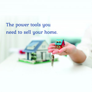 Hand holding a miniature house and key, representing selling a home.