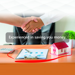 Handshake over a desk with a house model and financial documents