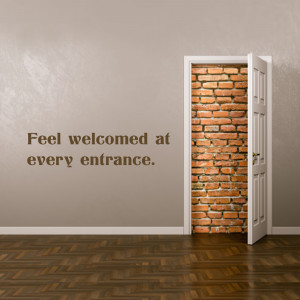 A white door is open revealing a brick wall behind a beige wall. Text reads 'Feel welcomed at every entrance.'