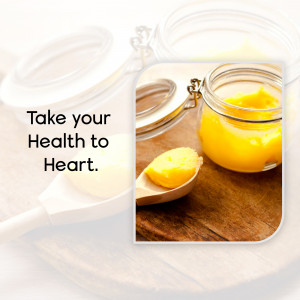 Close-up of ghee in glass jars with a wooden spoon