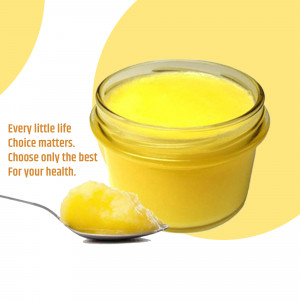 A jar of golden ghee with a spoonful on a silver spoon