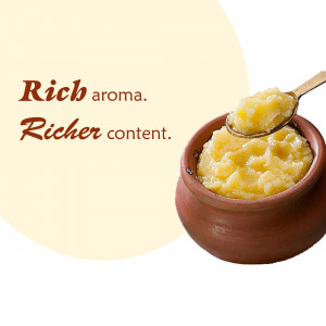 A close-up of ghee in a traditional clay pot with a spoon.