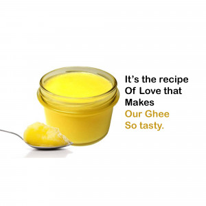 Jar of golden ghee with a spoonful on a white surface