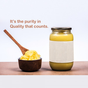 Jar of ghee with a wooden spoon and a small bowl of ghee